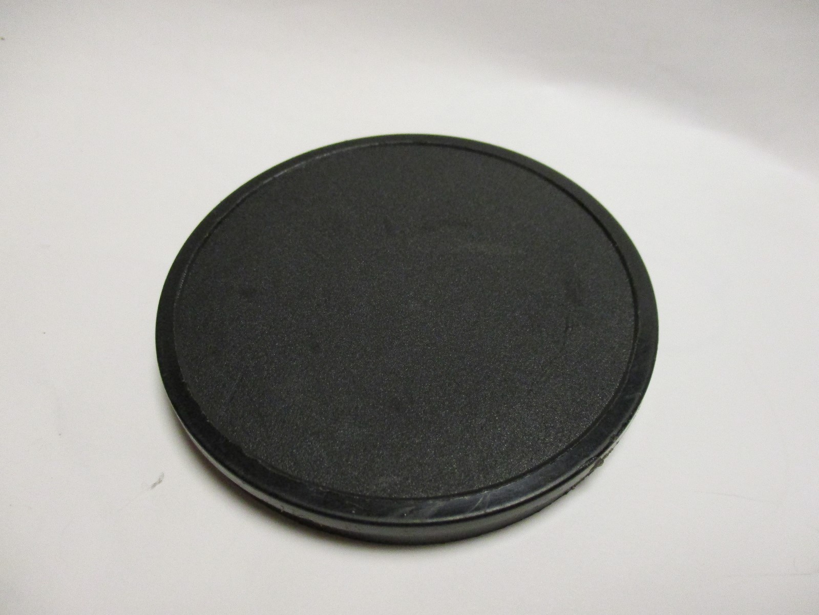 Black plasic push on 70mm lens cap. Made in Germany