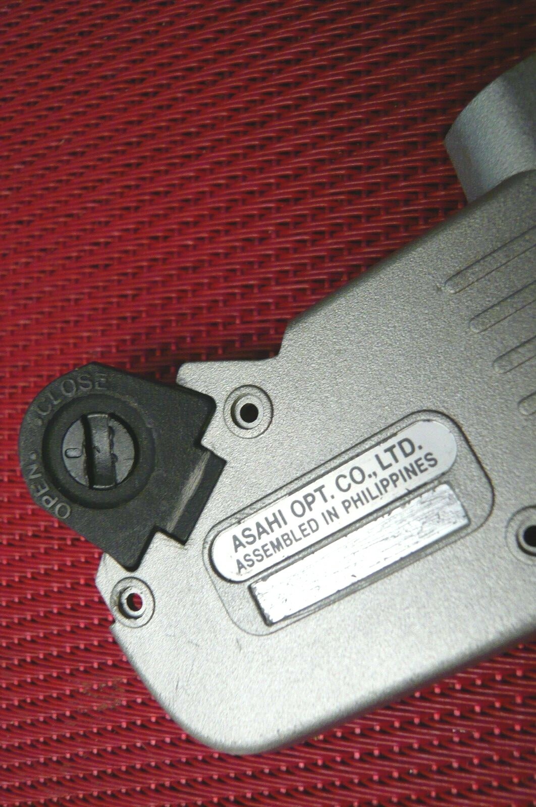 Bottom plate with battery door for Pentax ZX 10 camera.