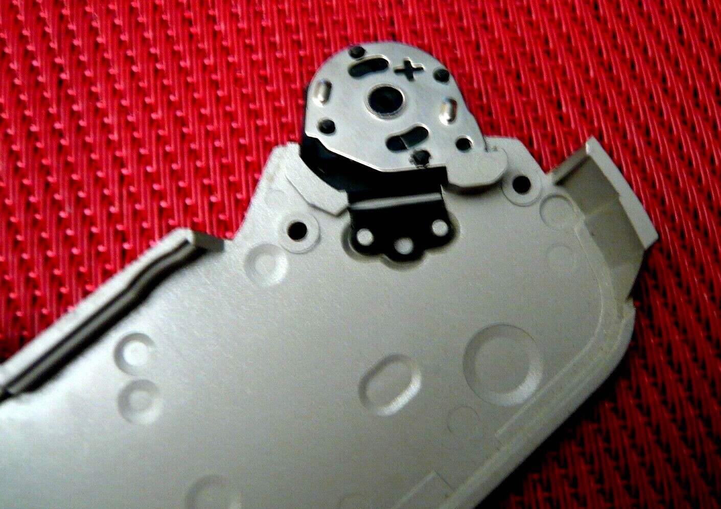 Bottom plate with battery door for Pentax ZX 10 camera.