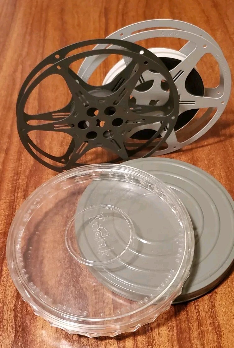 Two 16mm film cans and reels from 1960s. One Of Them Has A Colored Movie.