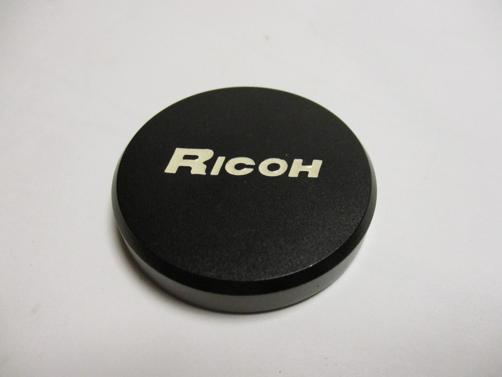 Ricoh black metal push on lens cap. Looks to be inside dia. of 43mm.