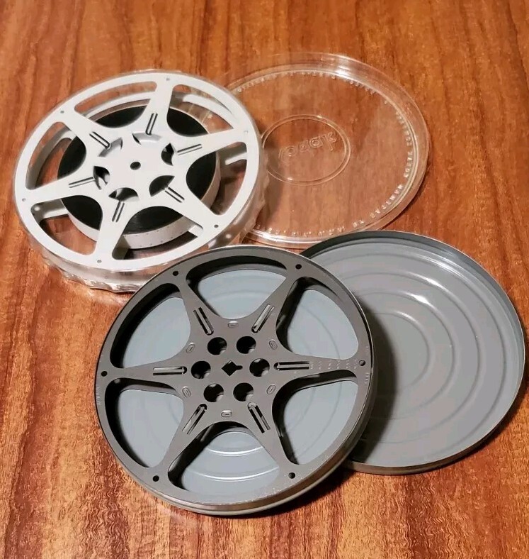 Two 16mm film cans and reels from 1960s. One Of Them Has A Colored Movie.