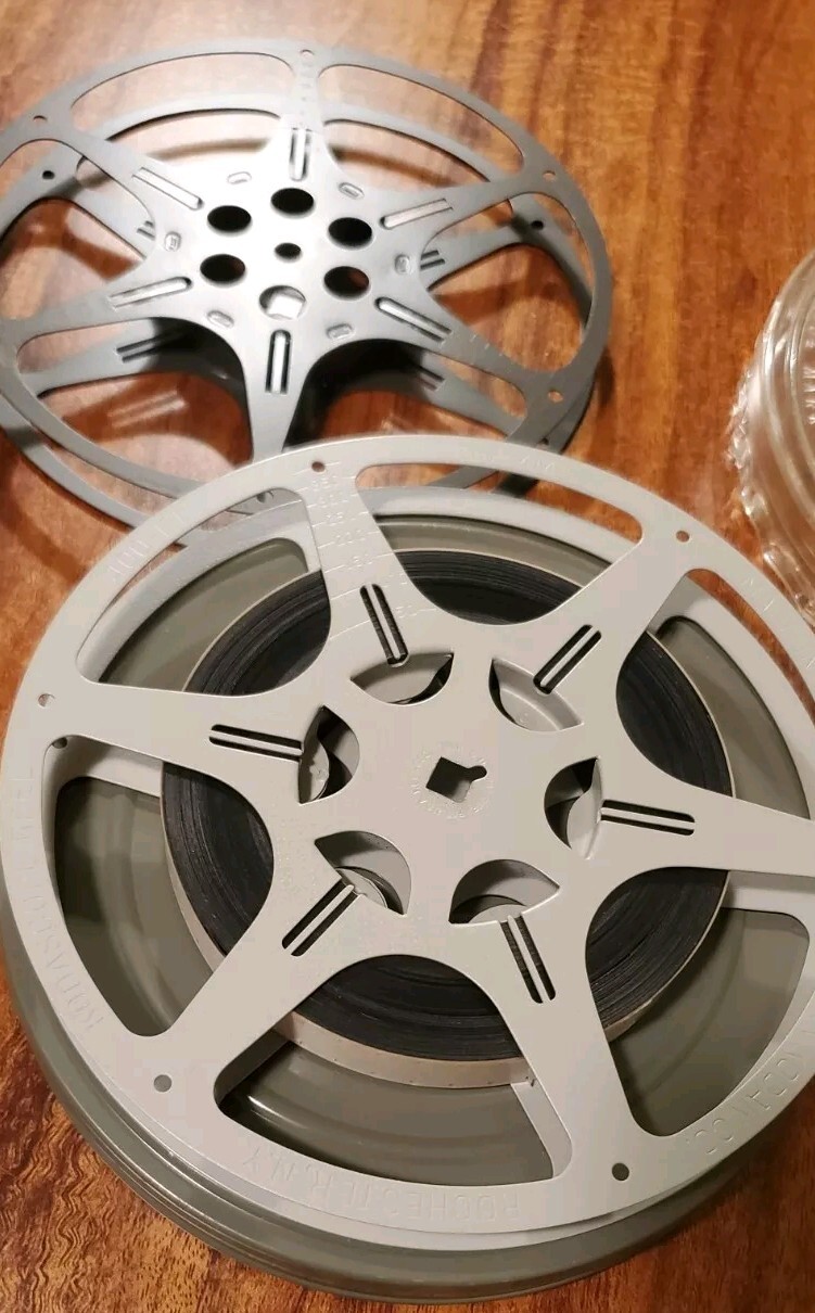 Two 16mm film cans and reels from 1960s. One Of Them Has A Colored Movie.